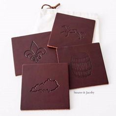 four leather coasters with designs on them