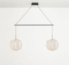 two white lamps hanging from the ceiling in a room