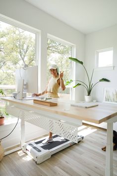 a person sitting at a desk on a treadmill