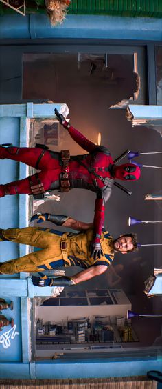 two women dressed in red and yellow standing on top of a metal structure with their arms outstretched