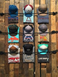 several hats are hanging on a wooden wall