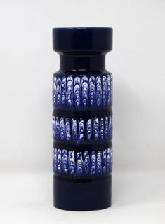 a tall blue vase sitting on top of a white table