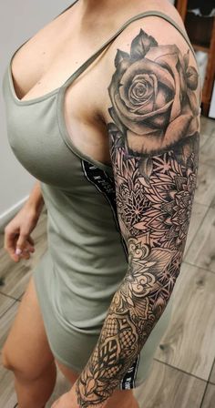 a woman with a rose tattoo on her arm and shoulder is posing for the camera