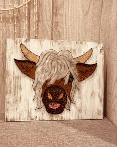 a wooden sign with a cow's head painted on it