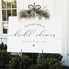 a sign that says, valentine's bride shower on it in front of some bushes