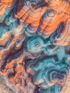 an aerial view of colorful rocks in the desert, with blue and orange colors on them