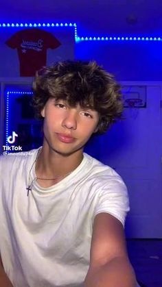 a young man sitting in front of a blue light