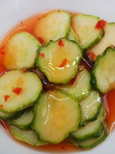 sliced cucumbers with sauce in a white bowl