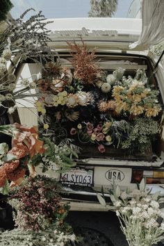 an old car with flowers in the back