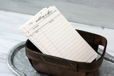 a wooden tray with a notepad and pen in it on top of a table