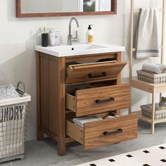 a bathroom vanity with drawers and a mirror above it