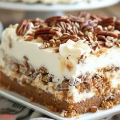 a piece of cake on a plate with pecans around the edges and frosting