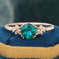 a green ring with white diamonds on it sitting on top of a blue cushioned pillow