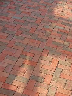 a red fire hydrant sitting on the side of a brick road next to a tree