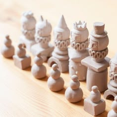 a group of clay figurines sitting on top of a wooden table next to each other