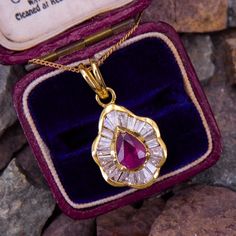 This regal pendant necklace is centered with one (1) pear cut natural ruby set into a three-prong setting. The ruby is bordered with twenty-two (22) channel set tapered baguette cut diamonds. The pendant measures 25.7mm by 13.2mm and is suspended from a delicate 18k yellow gold chain that measures 16 inches. The chain is stamped with Swedish hallmarks. Vintage Ruby Rings, Ruby Diamond Pendant, Antique Engagement Rings Sapphire, Baguette Diamond Necklace, Ruby Ring Vintage, Estate Jewelry Rings, Chanel Set, Ruby Set, Wedding Ring Diamond Band