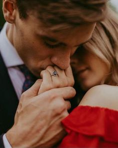 a man and woman are holding each other close to one another with their hands together