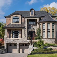 a large brick house with two car garages on the front and second story windows