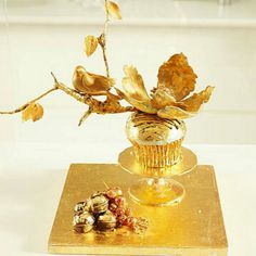 a cupcake decorated with gold leaves and nuts