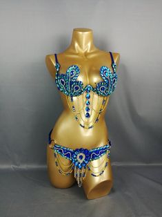 a gold mannequin with blue beads on it's chest and underwires