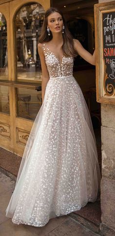 a woman standing in front of a store wearing a dress with flowers on the skirt