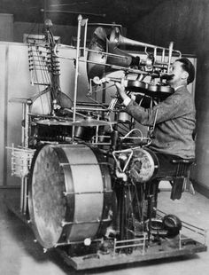 an old photo of a man working on a machine