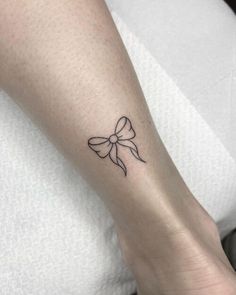 a small bow tattoo on the ankle