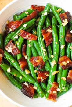 green beans with bacon and pine nuts in a white bowl