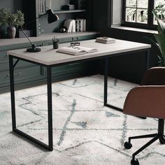 an office with a desk, chair and bookshelf in front of the window