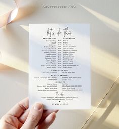 a person holding up a wedding program