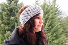 a woman wearing a crocheted headband with trees in the background