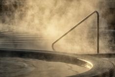 a hot tub with steam coming out of it's sides and water around it