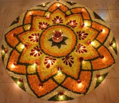 a circular arrangement of flowers and candles on the floor