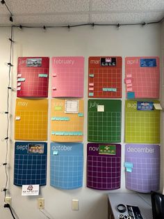 a wall with several calendars mounted to it's sides and hanging from the ceiling