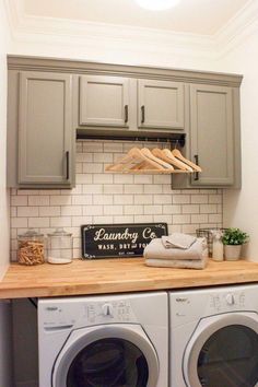 a washer and dryer in a laundry room with wooden counter tops on the floor