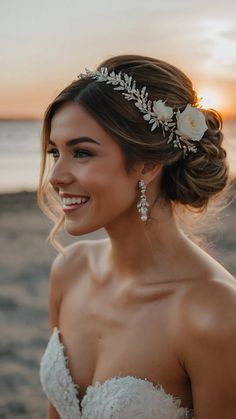 a woman in a wedding dress on the beach with her hair pinned back into a bun