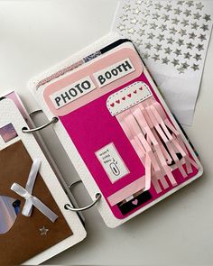 a pink photo booth is next to an envelope and some other things on the table