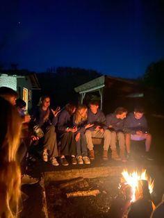 a group of people sitting around a campfire