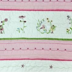 a pink and green quilt with flowers on it