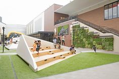 people are walking up and down the stairs in front of a building with green walls