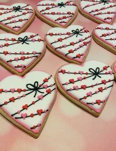 decorated heart shaped cookies are arranged on a table