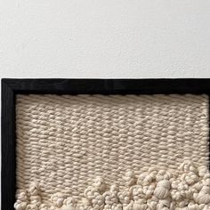 a black frame with some white yarn in it