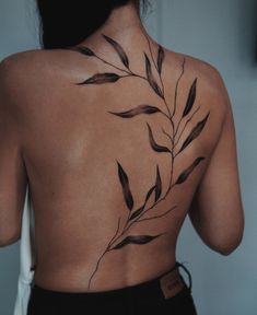 the back of a woman's body with leaves on her upper and lower back