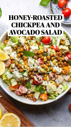 a salad with tomatoes, lettuce and chickpeas in a white bowl