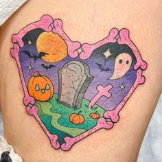 a woman's thigh with halloween tattoos on it and an image of a tombstone