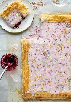 a piece of cake with sprinkles on it sitting next to a glass of wine