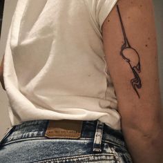 a woman's arm with a tattoo on it, and a hook in the middle