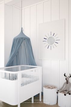 a baby's room with white walls and wood flooring, a blue canopy over the crib