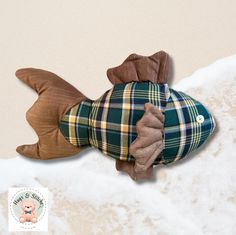 a stuffed animal laying on top of a bed covered in blankets and flannel