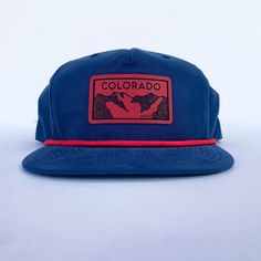 Everyone loves a good, comfy hat. How about one with a little bit of flair that helps you rep your favorite state?! Ooohhh yeah, we have our Colorado mountains patch now in red on a navy five panel rope hat! Grab your today for your next mountain adventure! Moisture wicking with UPF 50+ tech. One size. Adjustable. Outdoor Snapback Hat With Flat Bill Made In Usa, Red Flat Bill Hats For Outdoor Activities, Navy Trucker Hat With Flat Brim For Outdoor, Red 5-panel Hat For Outdoor, Red 5-panel Outdoor Hat, Red Baseball Cap Snapback For Outdoor Activities, Red Snapback Hat With Curved Bill For Outdoor, Red Snapback Baseball Cap For Outdoor Activities, Red Snapback Hat For Outdoor Activities